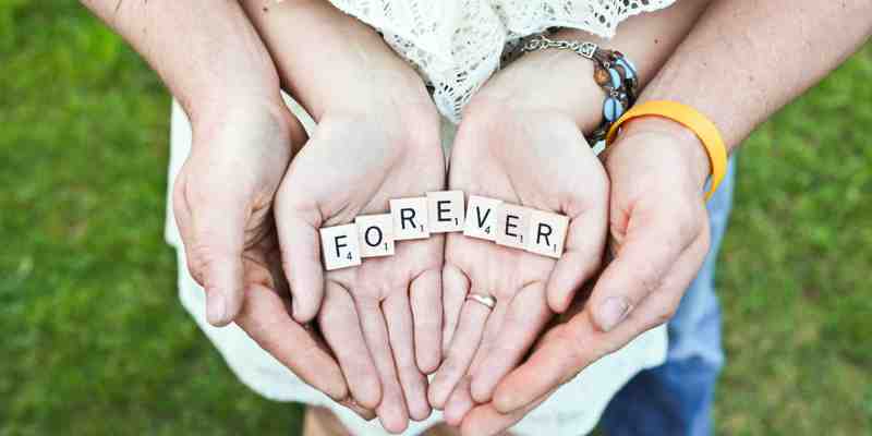 Two hands writing out forever with blocks